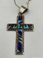 Front view of inlay cross pendant showing stones and silver border