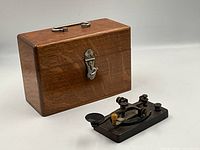 Telegraph key and wooden battery box side by side