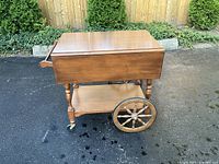Full side view of wooden tea cart showing drop-leaf top, large spoke wheels and lower shelf
