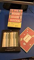 Boxed soft touch pens, Book Club socks set, sticky notes pad closed