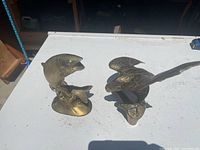 both brass figurines side by side