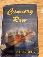 Front of Cannery Row dust jacket showing title and illustration, visible wear
