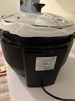 Front view of Instant slow cooker with glass lid and power cord visible