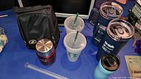 Overall lot view with lunch bag, Thermos jar, Starbucks cups, travel tumblers, turquoise mug, straw