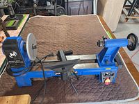 Full view of Mastercraft blue benchtop wood lathe on table