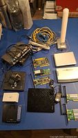 All items laid out: routers, switch, modem, cards, antenna, cables