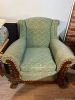 Front view of carved upholstered armchair