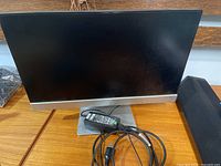 Front view of HP monitor on stand with cables