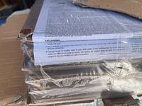 Side view of shrink-wrapped hardwood planks inside opened carton