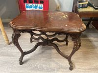 full view of ornate wooden end table showing legs and stretcher