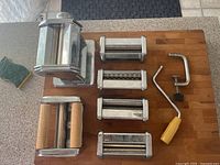 All components laid out: base, five attachments, crank, clamp