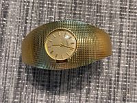 Front view of gold-filled cuff watch showing dial and textured surface