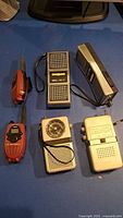 All six devices arranged: 2 Motorola, 2 WS-23, 2 silver radios