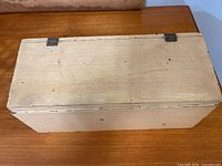 Closed top view of rectangular cream wooden box showing wear