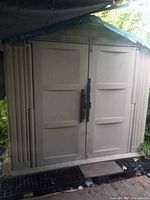 Front exterior view of closed shed showing double doors and resin construction