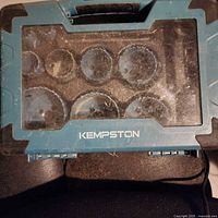 Closed view of the blue Kempston carry case with clear plastic lid showing circular outlines of hole saw blades stored inside.