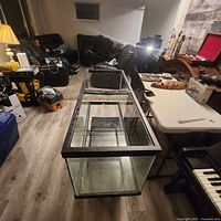 Full view of the large rectangular glass aquarium tank positioned in a room with visible black frame and clear glass walls.