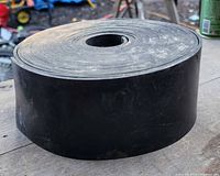 Large roll of thick black rubber strip approximately 4 inches wide.