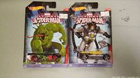 Two Hot Wheels Marvel Ultimate Spider-Man diecast cars sealed on cardback, 'Power Pythons' and 'Mega FX-7' models.