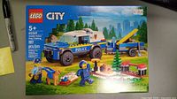 Front view of the sealed Lego City set box showing police vehicle, dog trailer, minifigures, and dogs on front image, with 197 pieces count visible.