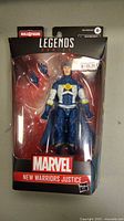 Front view of sealed Marvel Legends New Warriors Justice action figure in packaging showing figure and included accessories