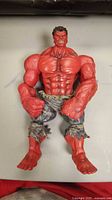 Front view of the Red Hulk figure showcasing muscular red body and torn pants.