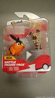 Photo showing sealed blister pack with Tepig and Rockruff figures visible inside packaging, labelled 'Battle Ready Battle Figure Pack'