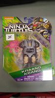 Front view of sealed Teenage Mutant Ninja Turtles Kraang action figure in blister pack with pink brain accessory.