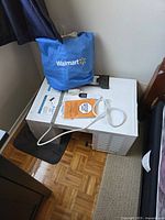 Unit on its side with remote and power cord visible