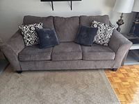 front view of grey three-seat sofa with four cushions