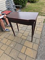 Full view of dark wood console game table outdoors