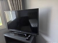 LG flat screen TV with Blu-ray player beneath