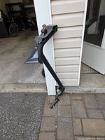 Full view of SportRack bike carrier leaning against siding