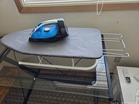Steam iron resting on tabletop ironing board