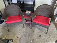 Overall view of the two wicker chairs, red side table and citronella holder
