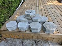 Stack of hexagonal paving stones on wooden deck