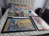 Overview of puzzle boxes, sorting trays and two framed puzzles on bed