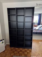 Front view of three black Billy bookcases side by side