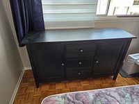 Front view of black painted pine sideboard against wall