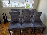 Six grey velvet diamond-tufted dining chairs front view