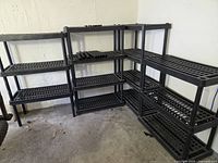 Overall view of L-shaped arrangement of three shelving units showing grid shelves and spare tubes