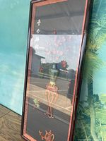 Full view of the framed artwork with visible floral accents and reflections on the glass.