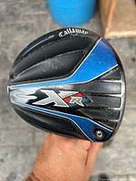 Callaway XR driver golf club head facing upward showing branding, XR logo, and blue-black finish with some wear marks.