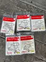 Photo of the six sealed plastic covers including three sofa covers, two chair covers, and one mattress bag cover.