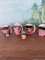 Full view of all five sailor face toby style mugs with detailed ceramic features and handles.