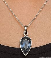 Pendant shown on display chain against black background