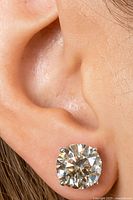 Single earring worn on ear for scale