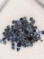 Loose genuine sapphire stones grouped together, showing various cuts and blue tones