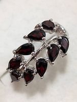 Sterling silver ring with a cluster of pear-shaped garnet stones set in a leaf pattern