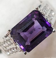 Close-up of the sterling silver ring featuring a rectangular emerald-cut amethyst gemstone showing the gemstone's faceting and deep violet color.
